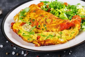 huevos revueltos con verduras, desayuno rico en proteína